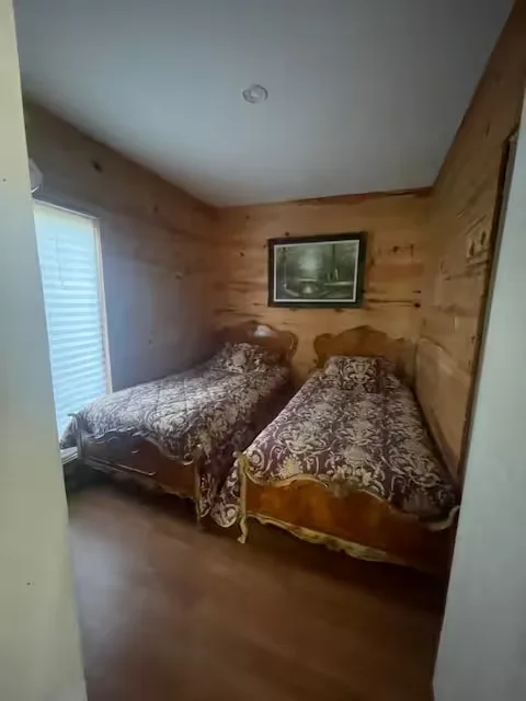 Twin bedroom with antique beds and wood walls