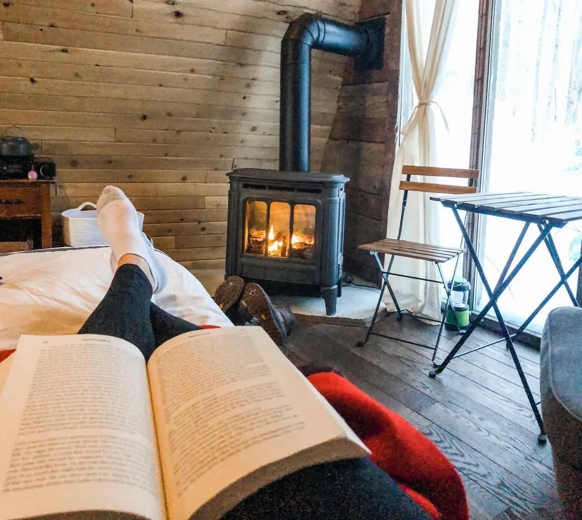 Reading by the fire inside the cabin