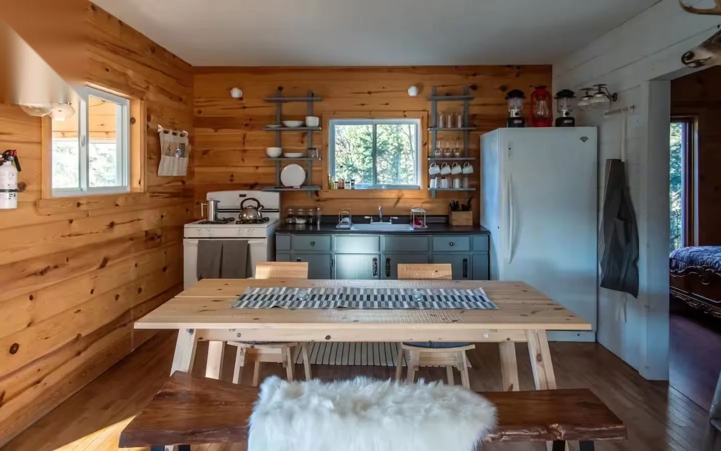 Charming kitchen with gas stove, teal cabinets, and open shelving