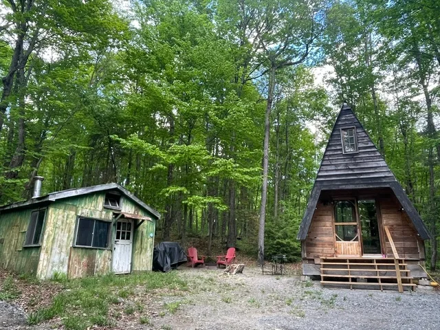 A-Frame cabin exterior in summer with firepit