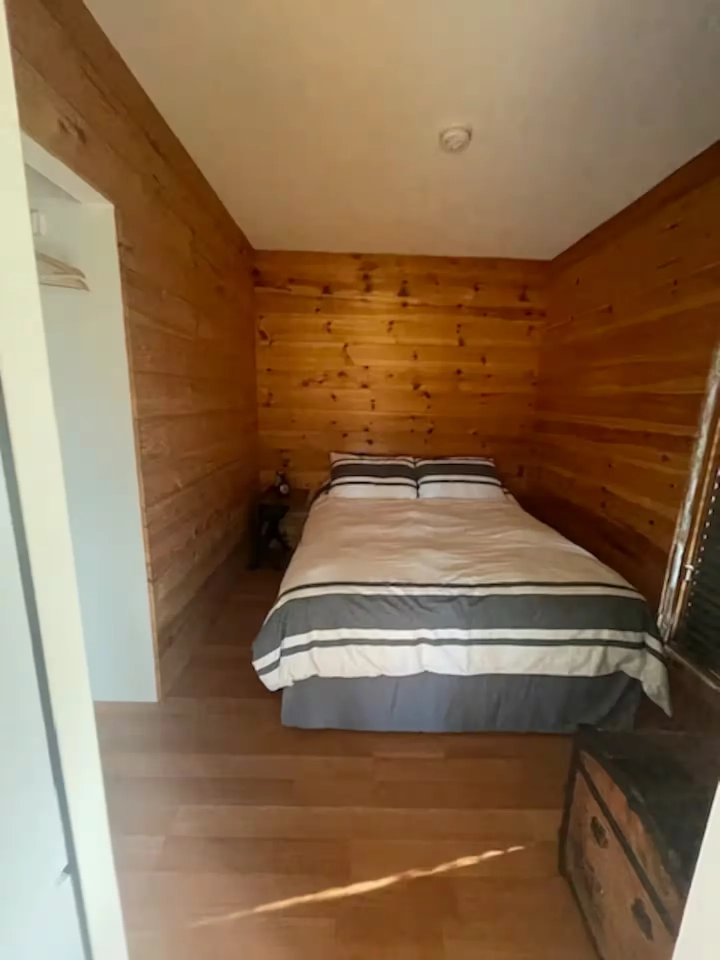 Cozy queen bedroom with wood-panelled walls