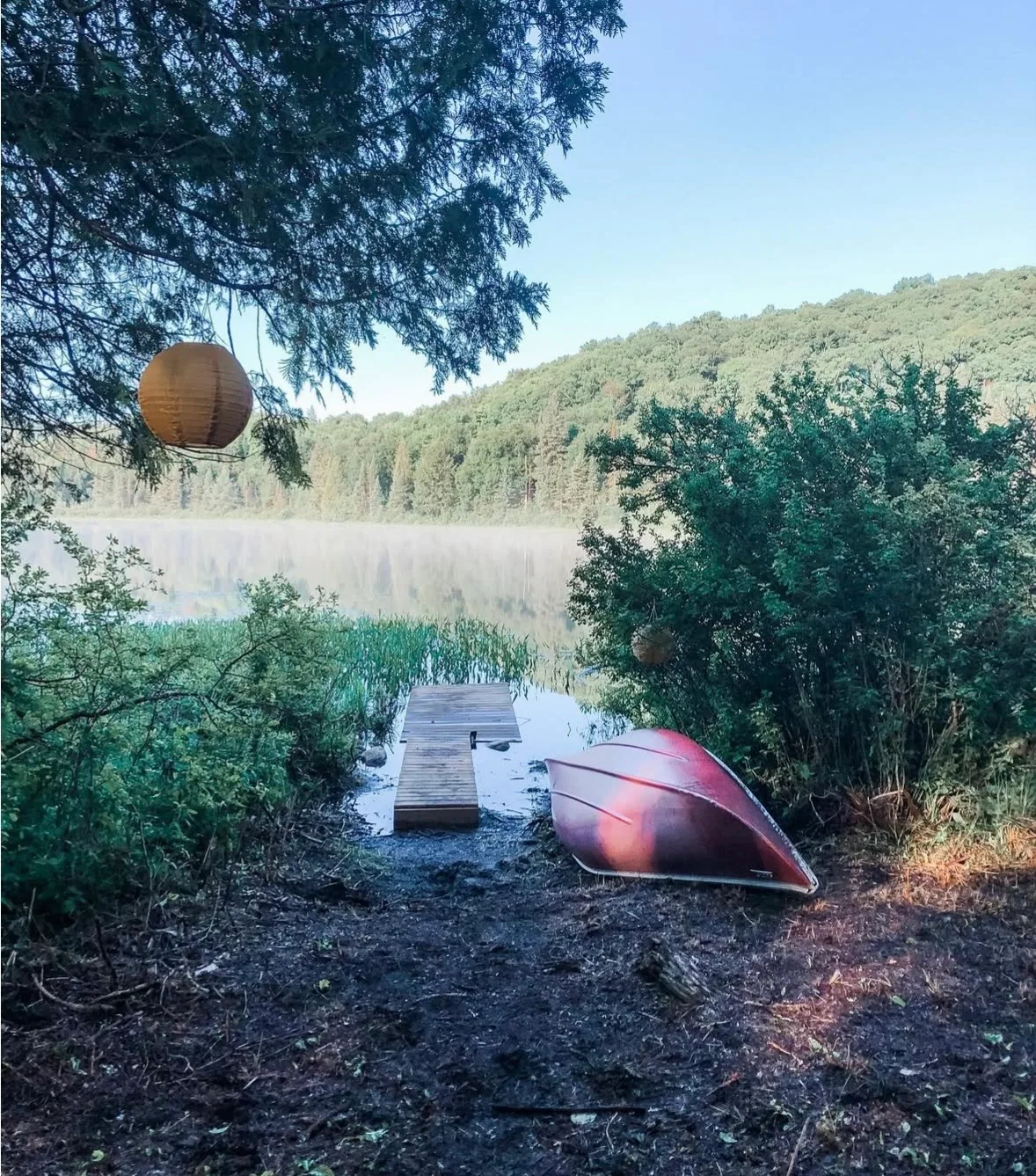 Lake dock and canoe on a summer morning